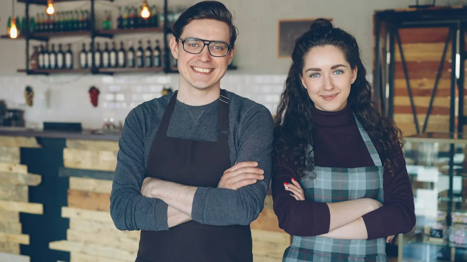 Two café owners standing proudly in their shop